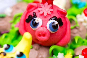 Naklejka premium Celebration colorful cake decorated with fruit, chocolate and figures of animals for kids party