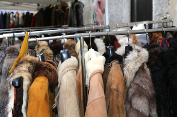 Fototapeta na wymiar jackets fur coat hanging and second-hand clothes for sale in fl