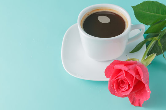 cup of coffee on the table with rose flower