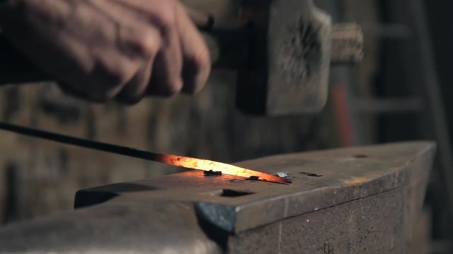 Forgeron ferronnier tape sur une enclume