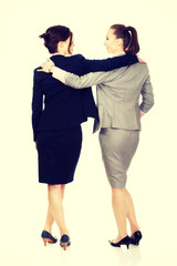 Two women embracing each other.