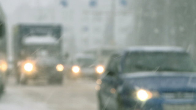 Snow storm.Cars driving in the city during a snowfall. Slow motion.