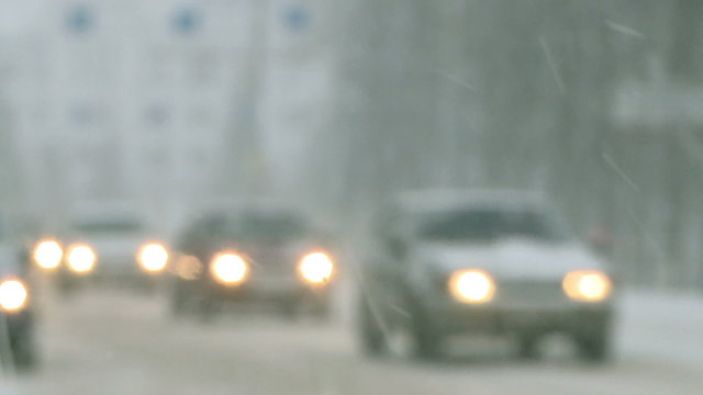 Snow storm.Cars driving in the city during a snowfall.