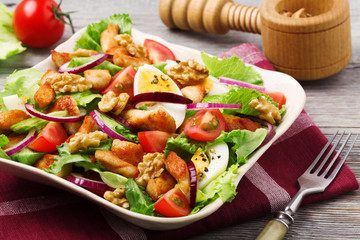 Delicious salad with chicken, nuts, egg and vegetables.