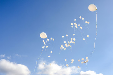 White balloons flying in the sky