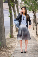 Woman in urban background talking with smartphone