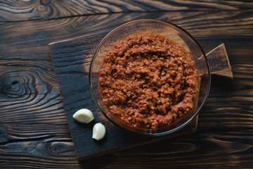 Bolognese sauce in a glass bowl on a rustic wooden background