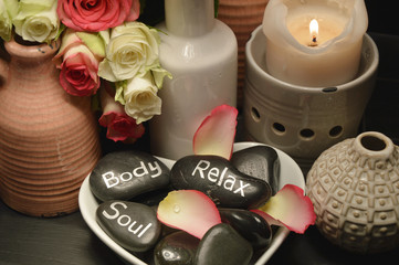 Obraz na płótnie Canvas Roses spa with candle light Spa equipment with pink and white roses on the black wooden tray 