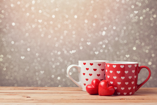 Valentine's day holiday celebration with hearts and cups over bokeh background