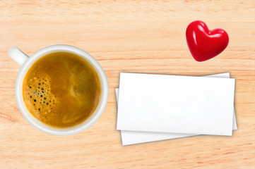 Cup of coffee and envelops on wooden table, top view