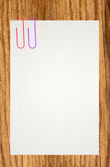 White sheet of paper attached on wooden background