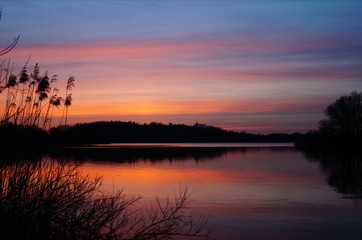 Calm lake reflecting the sunset sky