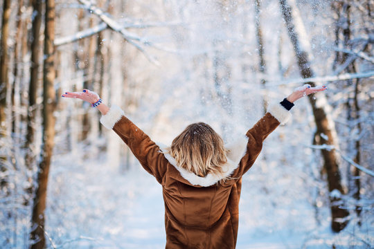 Blonde Young Woman Standing In Snowfall