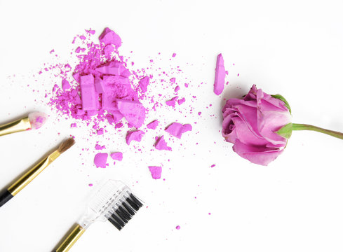 Violet rose and cosmetic powder on white background