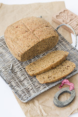 Naklejka premium Wheat bread. Buckweat bread with dried tomatoes and thyme, on white background, basket and grey paper. 