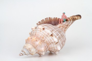 miniature di bagnanti in relax su una grande conchiglia