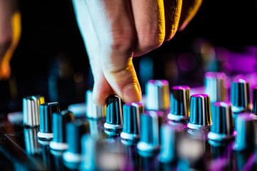 Dj mixes the track in the nightclub.