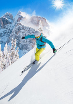 Skier skiing downhill in high mountains