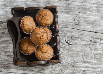 Oatmeal and banana  muffins in vintage tray on rustic light wooden board.
