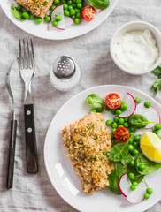 Baked salmon with lemon bread crust and fresh vegetable salad with peas, spinach, radishes and cherry tomatoes. Delicious healthy dinner