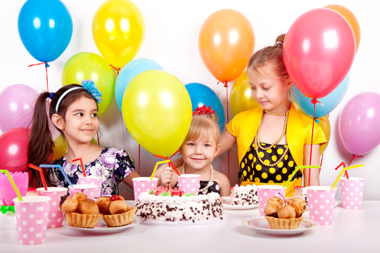 Three beautiful happy baby with balloons celebrating birthday