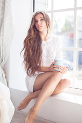 Beautiful lady sitting by the window indoor