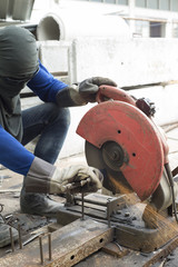 Worker cutting steel in construction site.
