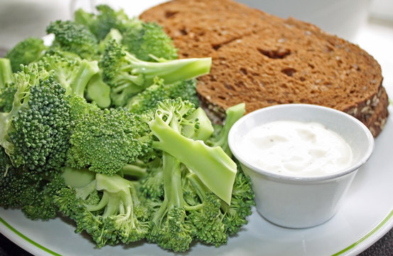 Nutritious Rye bread sandwich with a side of fresh Broccoli and a dipping sauce
