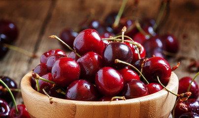Sweet ripe cherry in a wooden bowl, selective jarec