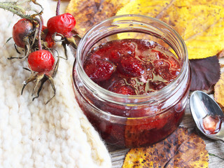 homemade jam in a glass jar on the table with leaves