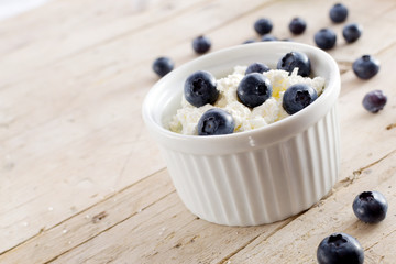 Cottage cheese with blueberries on wood