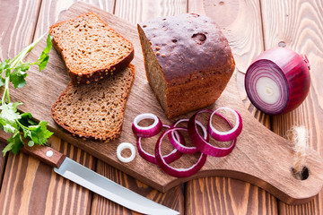 Fototapeta na wymiar bread with bran and vegetables on a cutting board