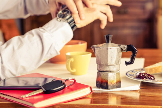 Old mocha coffee machine with businessman hands checking the time and breakfast mugs as background - Vintage coffeepot  on home table - Concept of business man at breakfast time ready for working day