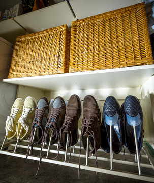 Some Pairs Of Men's Shoes On SHOE RACK In The Storeroom At Home