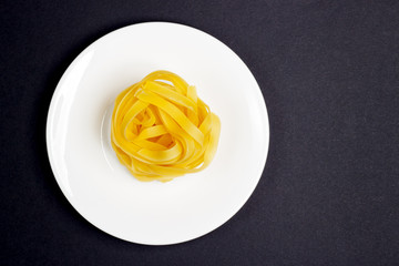 Pasta on the white plate, black background