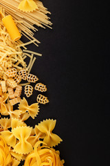 Different types of pasta on the black background