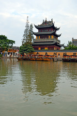 Fototapeta premium Old village by river in Shanghai with boat..