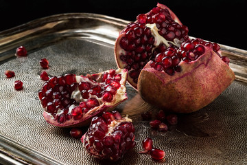 Pieces of a pomegranate with grains on a tray