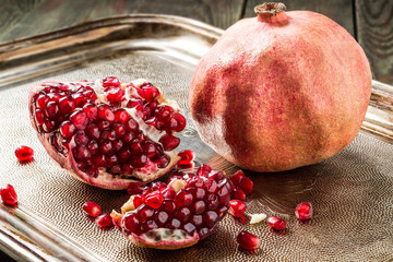 Ripe pomegranate and pieces with grains