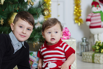 boy and girl near a Christmas tree

