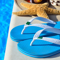 Woman beach hat, bright towel and blue flip-flops