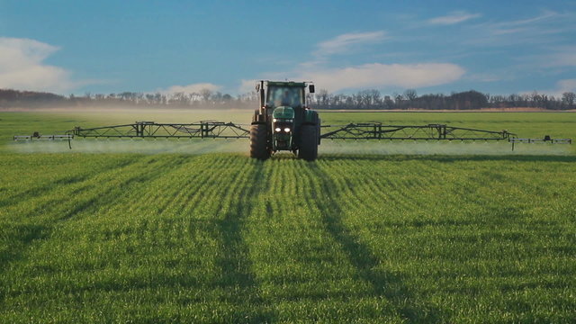 Tractor spraying the field with chemicals.