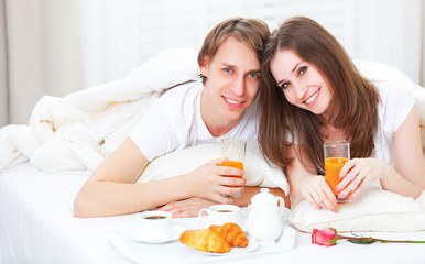 Obraz na płótnie Canvas loving couple having breakfast in bed