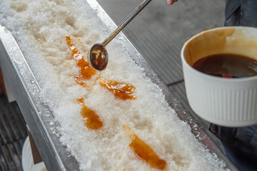 Maple taffy on snow during sugar shack period. In Quebec, Canada