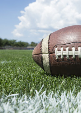 Closeup photo of a football resting on an outdoor field