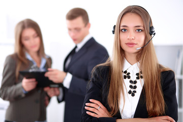 Portrait of beautiful cheerful smiling call operator on the background of business people. Successful call center concept