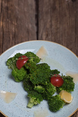 Boiled broccoli with tomatoes, lemon and herbs