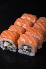 Sushi rolls on a black background, Japanese cuisine