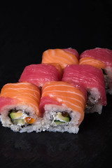 Sushi rolls on a black background, Japanese cuisine