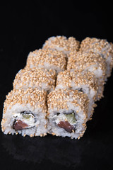 Sushi rolls on a black background, Japanese cuisine